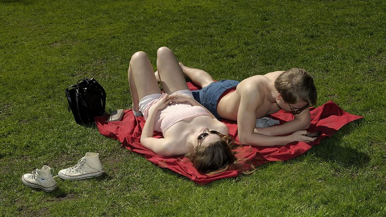 Anni Tolppanen ja Rudolf Koivu nauttivat lämmöstä Vanhassa kirkkopuistossa Helsingissä 16. toukokuuta 2013.