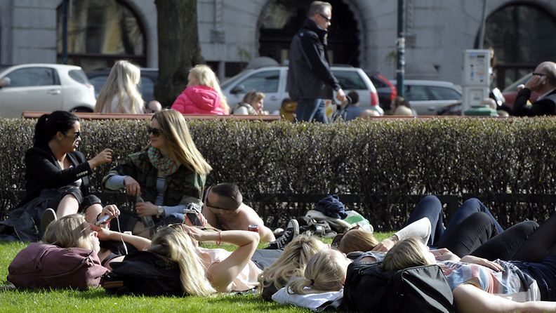 Ihmiset nauttivat lämpimästä säästä Esplanadin puistossa Helsingissä 8. toukokuuta 2013.