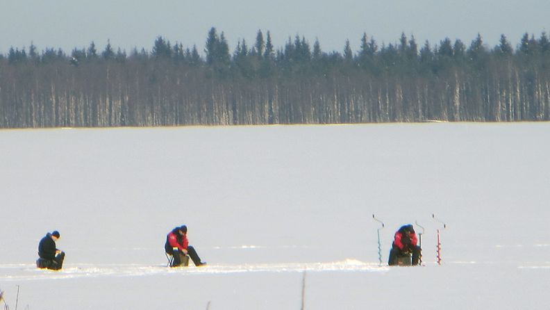 Kevät helli päiväsaikaan Pohjois-Pohjanmaalla Pyhäjärven kaupungissa. Pilkkijät istuvat Pyhäjoen jäätiköllä.