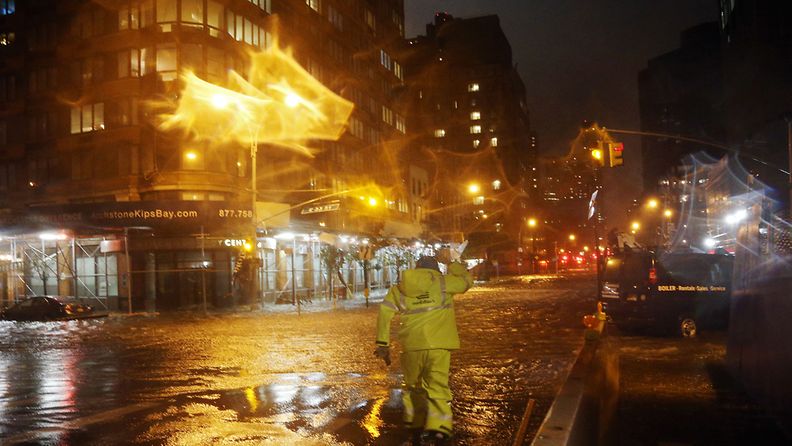 (NEW YORK, NY - OCTOBER 29: A Con Edison worker walks through the flood waters on the corner of 33th Street and 1st Street in front of NYU Langone Medical Center in Manhattan during rains from Hurricane Sandy on October 29, 2012 in New York City. Hurricane Sandy, which threatens 50 million people in the eastern third of the U.S., is expected to bring days of rain, high winds and possibly heavy snow. New York Governor Andrew Cuomo announced the closure of all New York City bus, subway and commuter rail services as of Sunday evening. (Photo by Michael Heiman/Getty Images) )