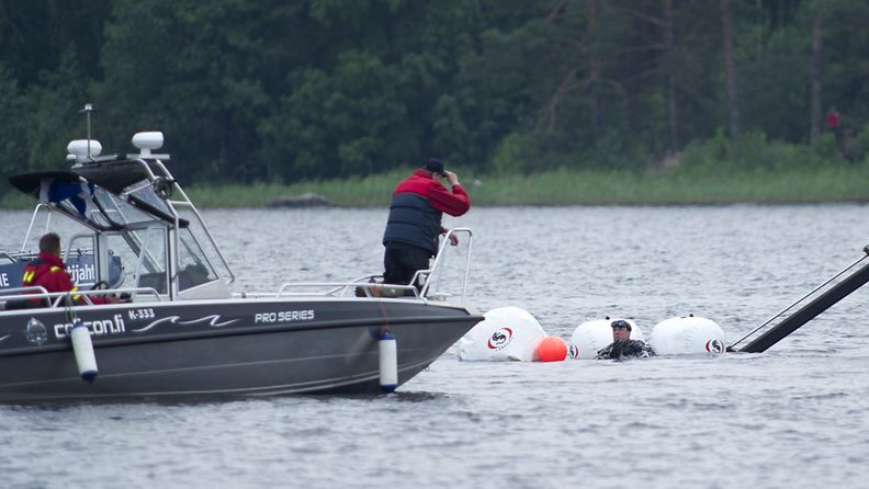 Kuopion Vehmersalmella lauantaina pudonnutta vesitasoa nostettiin järvestä 1. heinäkuuta 2013. Sukeltaja on kellukkeiden avulla pintaan nousseen rungon luona. 