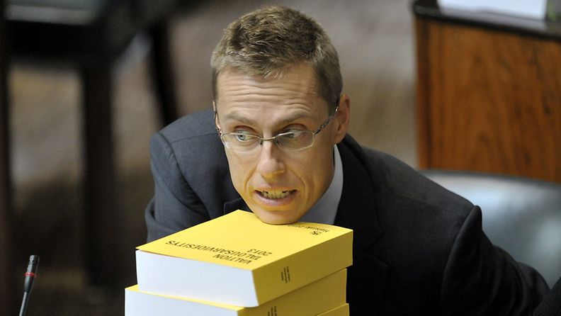 Kokoomuksen Alexander Stubb nojasi leukaansa budjettikirjoihin eduskunnan täysistunnossa Helsingissä perjantaina 21. syyskuuta 2012. 