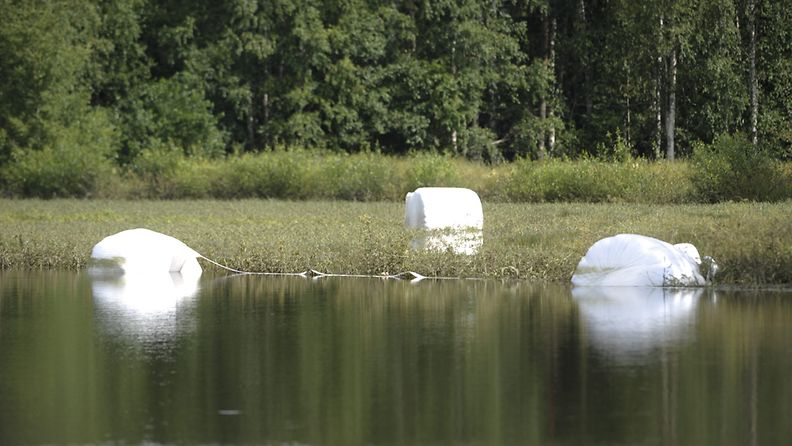 Tulvaveden valtaama pelto ja vedessä kelluvia tuorerehupaaleja Jalasjärvellä 15. heinäkuuta 2012.