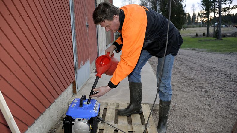 Pasi Laine laittaa polttoainetta aggregaattiin Salon Kiikalassa 28. joulukuuta 2011.
