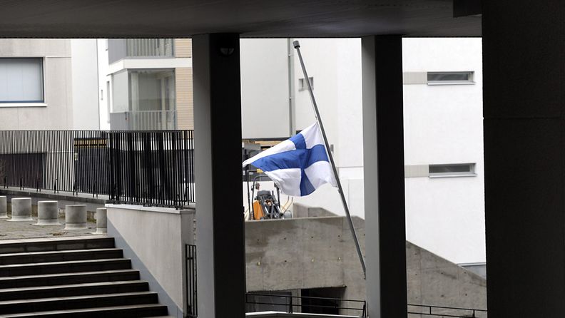 Lippu puolitangossa kerrostalon pihalla, missä surmattu perhe asui, Bulevardilla Helsingissä kuvattuna lauantaiaamuna 14. huhtikuuta 2012. 
