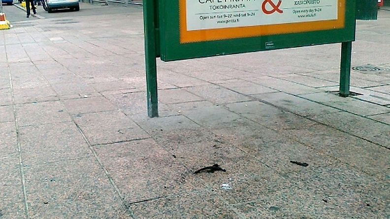 Palon jälkiä bussipysäkillä Helsingin Kampissa, jossa mies sytytettiin tuleen 4.7.2011.