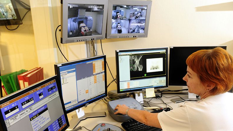 airaanhoitaja käyttää korkeaenergista sädehoitolaitetta syöpätautien klinikalla Meilahden sairaalassa Helsingissä 16.helmikuuta 2010. Potilas näkyy monitorissa.