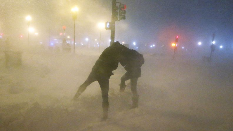 People shield themselves from the blowing snow as a blizzard arrives in the Back Bay neighborhood on February 8, 2013 in Boston, Massachusetts.
