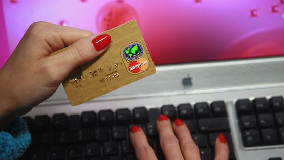 Nainen ostaa luottokortilla internetistä. (Lehtikuva)