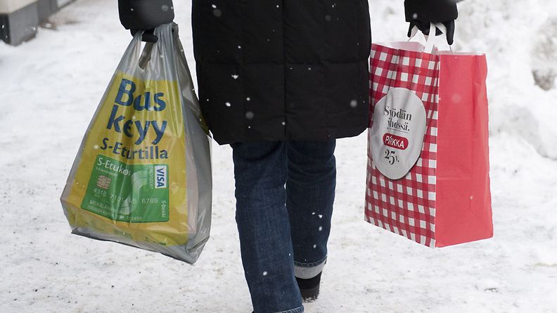 Nainen kantaa S-ryhmän ja K-ryhmän ruokakasseja Helsingin keskustassa 10. tammikuuta 2012.