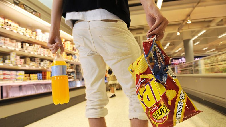 Nuori ostaa perunalastuja, karkkeja ja virvoitusjuomaa K-supermarketissa 18. elokuuta 2010.
