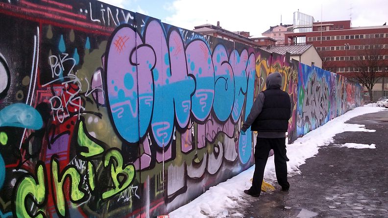 Graffititaiteilija Ghost työssään Helsingin Suvilahdessa.