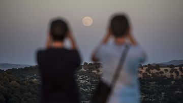 Ihmiset katselevat superkuuta Cordobassa Etelä-Espanjassa 10. elokuuta 2014.