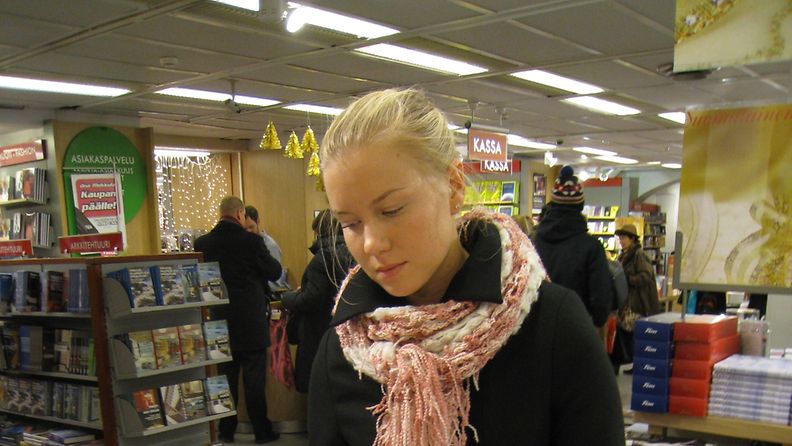 Heidi Häyrinen selaa kirjoja kirjakaupassa.
