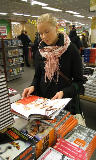 Heidi Häyrinen selaa kirjoja kirjakaupassa.
