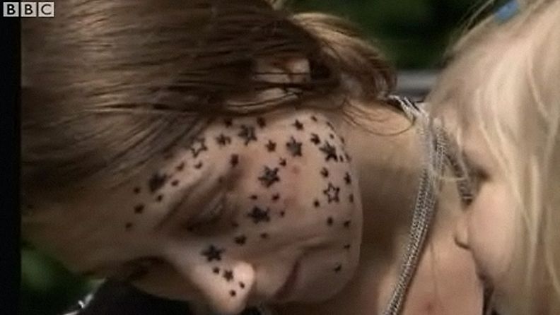 Belgialaistyttö aikoo haastaa oikeuteen tatuoijan, joka yltyi tatuoimaan tytön kasvoja hieman liikaa. Kuva BBC:n videosta.