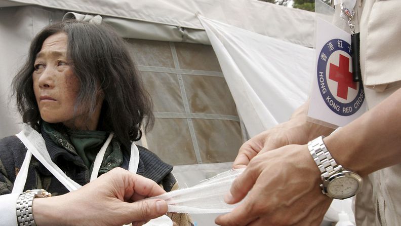 Kuvituskuva, kuvassa Punaisen ristin lääkäri hoitamassa maanjäristyksen uhria toukokuussa Kiinassa.