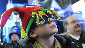 Nuori poika juhlii uutta vuotta New Yorkin Times Squarella. 