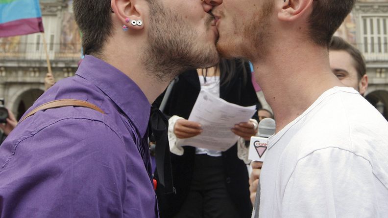 Kaksi nuorta miestä suutelee massahäätapahtumassa Madridissa Espanjassa. Kuva: EPA