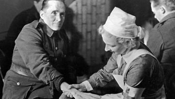 Punaisen Ristin sairaanhoitaja hoitaa sotilaan paleltunutta kättä 1. tammikuuta 1940 pohjoisrintamalla.