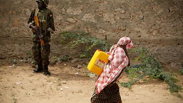 Avustusjärjestöt yrittävät auttaa Somalian kuivuudesta kärsivää kansaa, mutta tilanne on vaikea. Somalinainen kantaa vettä YK-sotilaan edessä Mogadishussa Somaliassa 15.7.2011 Kuva: EPA