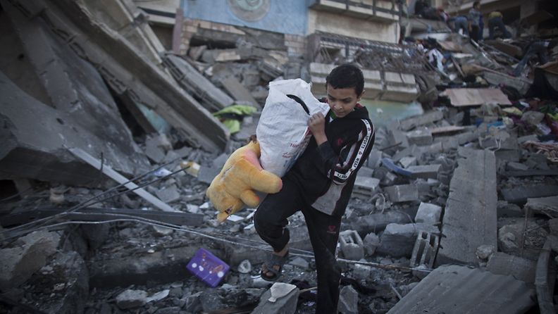 Palestiinalaispoika pelastaa pehmolelunsa tuhoutuneen talon raunioista 20.11.2012.