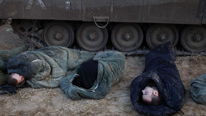 Israelilaissotilaat nukkuvat makuupusseissa. Kuva läheltä Gazan rajaa.