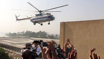 Ex-presidentti Mubarakin kannattajat vilkuttavat helikopterille, joka kuljetti Mubarakin oikeuteen Kairossa 27.9.2014.