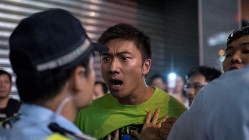 Mielenosoittaja huutaa paikalliselle poliisille Hongkongissa 4. lokakuuta 2014.