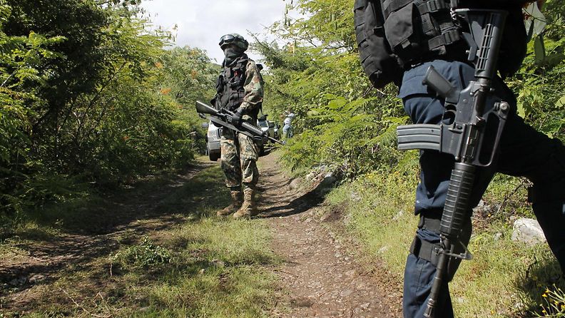 Meksikossa poliisi ja sotilas vartioivat aluetta, josta löytyi joukkohauta Guerreron osavaltiossa 4. lokakuuta 2014.