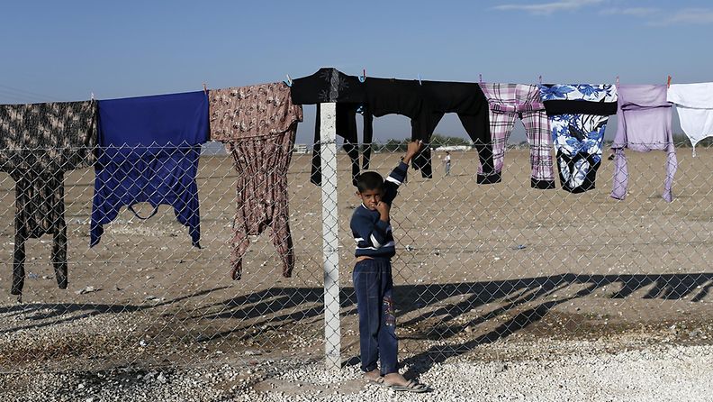 Syyrialaispoika seisoo pakolaisleirillä pyykkien alla Turkin puolella Sanliurfan kaupungissa 25.10.2014