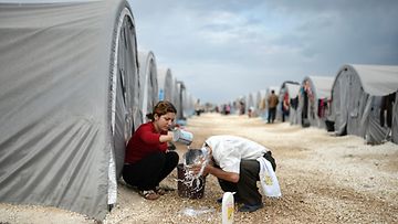 Kobanesta paenneet ihmiset yrittävät elää pakolaisleirillä Sanliurfan kaupungissa Turkissa. Nainen pesee miehen hiuksia 28.10.2014.