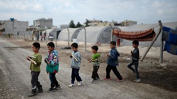 Kobanen kaupungista paenneet lapset leikkivät olevansa taistelijoita pakolaisleirillä Turkin puolella Sanliurfan kaupungissa. Kuva 28.10.2014.