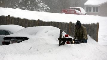 Mies kaivoi autoa lumesta Franklinissa Yhdysvaltojen koillisosassa 27. tammikuuta 2015.