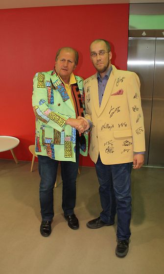 Juhani Tamminen luovutti Leijonien nimmareilla koristellun takin huutokaupan voittaneelle Patrickille.