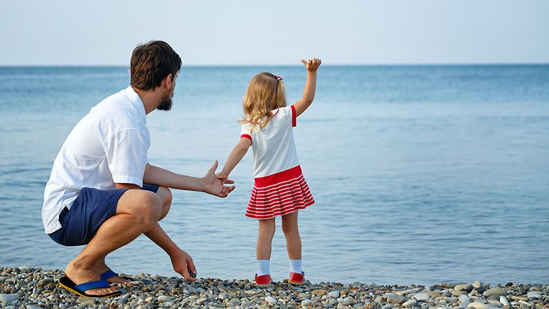 Isä ja tytär meren rannalla