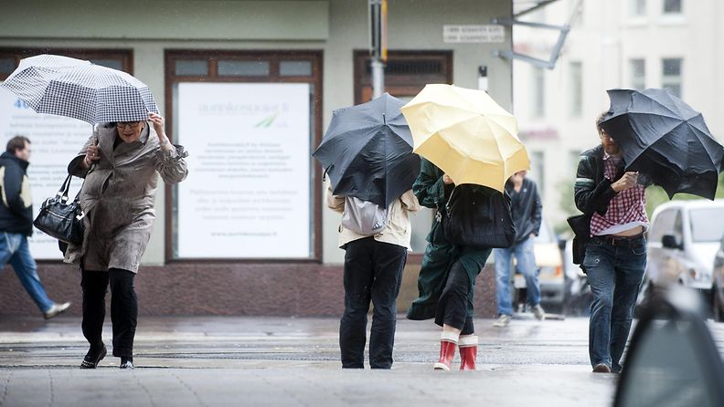 Ihmiset pitivät kiinni sateenvarjoistaan tuulisella Urho Kekkosen kadulla Kampissa Helsingissä 14. syyskuuta 2011.
