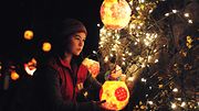 Nainen sytyttää lyhdyn talvipäivänseisausta juhlistavassa Winter Solstice Lantern Festival -juhlassa Vancouverissa, 2014 Copyright: Xinhua/Photoshot. All rights reserved./All Over Press. Photographer: Sergei Bachlakov.