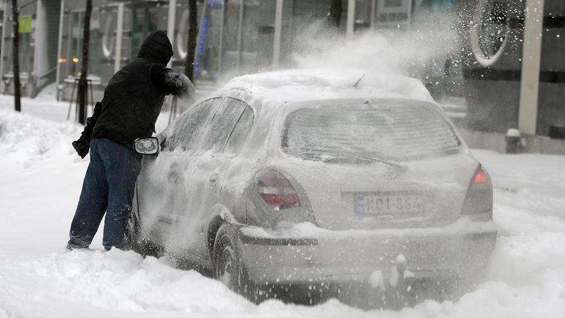 Autoa puhdistettiin lumesta Helsingin Ruoholahdessa 11. tammikuuta 2015.