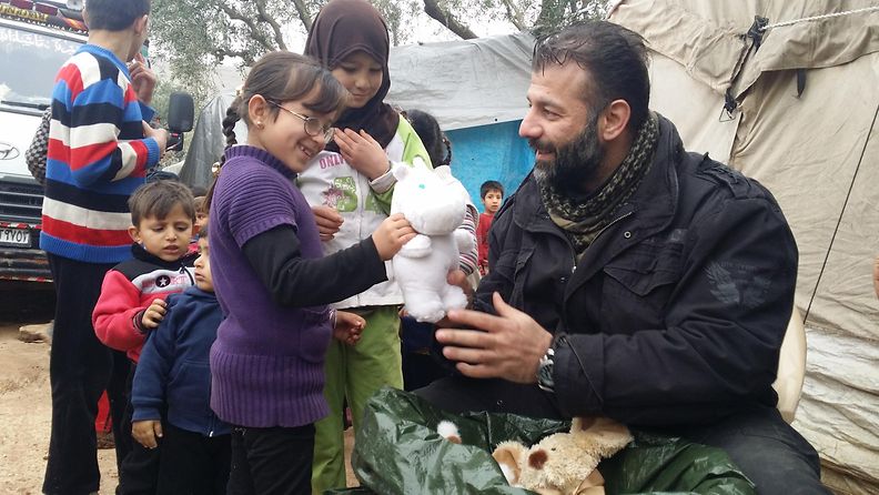 Avustustyöntekijä Rami Adham jakamassa leluja Syyrian pakolaisleirillä