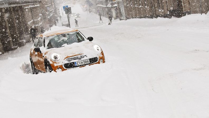 Auto jumissa lumikinoksissa Fabianinkadulla Helsingissä tiistaina 12. tammikuuta 2016. 