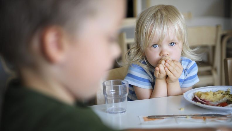 2-vuotias Wilhelmiina Koskinen syö pinaattilettuja Tuomarilan päiväkodissa Espoossa 6. elokuuta 2013. Etualalla 3-vuotias Lukas Louhento. LEHTIKUVA Aleksi Tuomola
