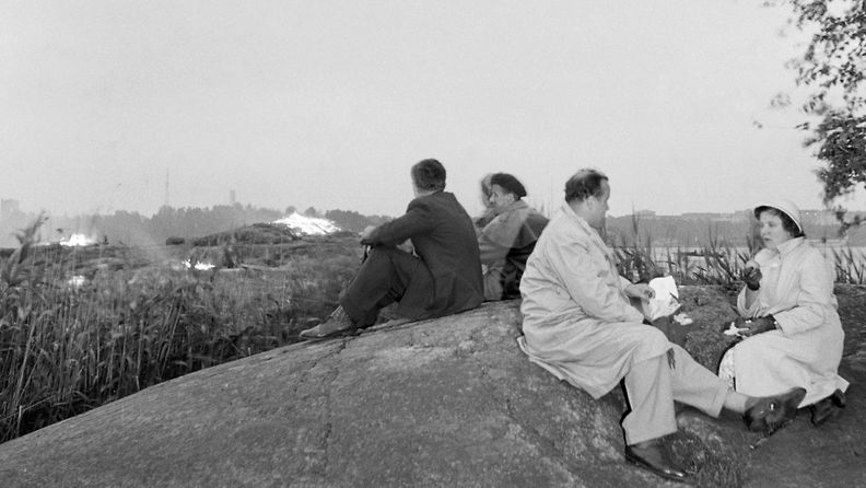 Pariskunta syö eväitään Seurasaren kalliolla juhannusaattona 1954. 