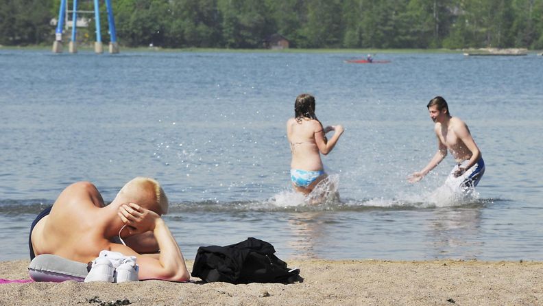 Uimareita ja auringonottajia Hietaniemen uimarannalla Helsingissä 25. toukokuuta 2016.