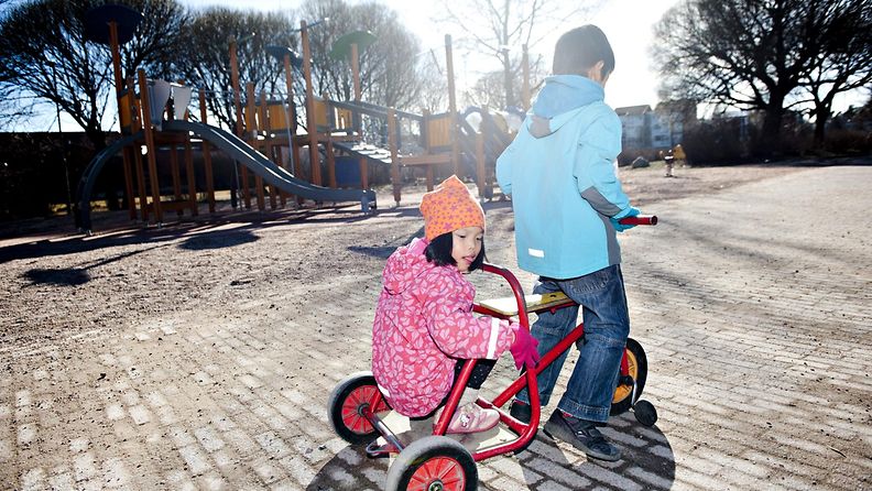 Sisarukset Aurora ja Arttu Aaltonen leikkivät pyörällä leikkipuistossa Helsingin Malmilla perjantaina 28. maaliskuuta 2014. LEHTIKUVA / MIKKO STIG.