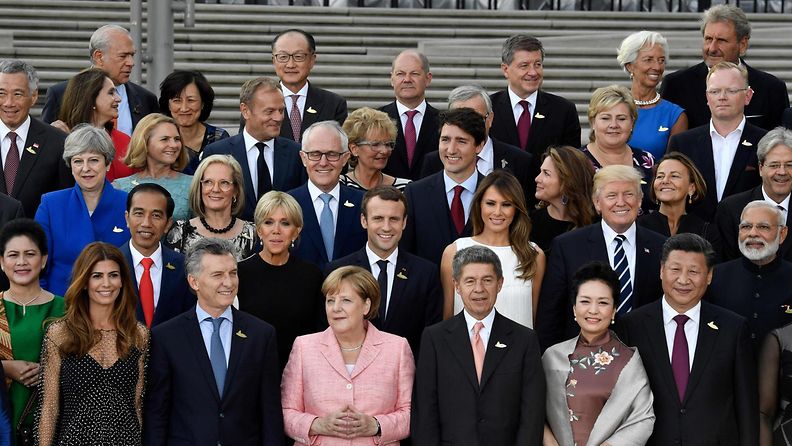 Saksan liittokansleri Angela Merkel ja hänen aviomiehensä Joachim Sauer poseeraavat G20-maiden kokoukseen osallistuvien kanssa Hampurissa.
