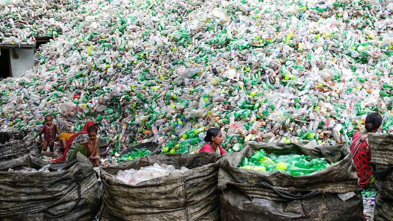 Naiset lajittelevat PET-muovipulloja Bangladeshin pääkaupunki Dhakassa.