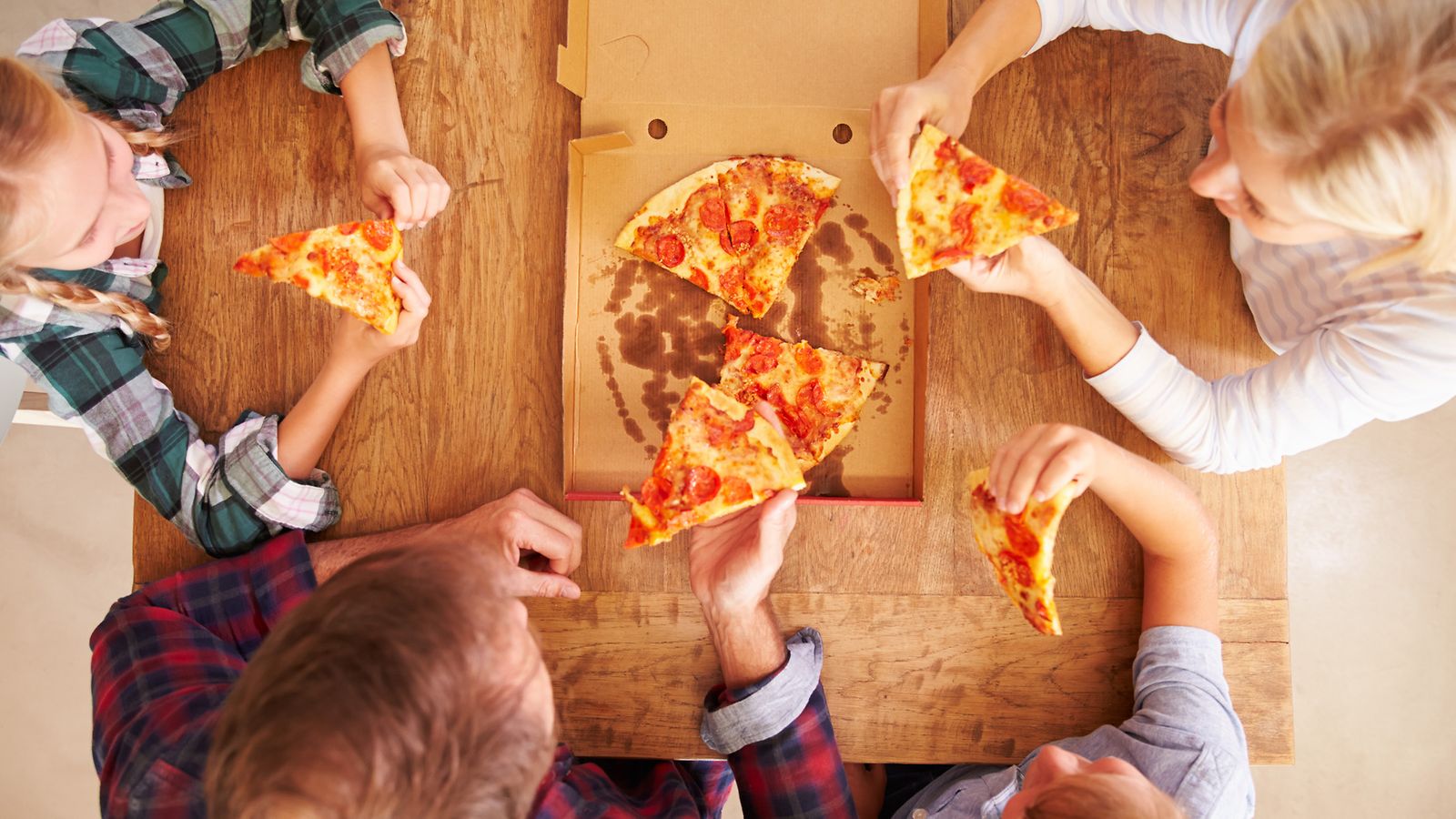 perhe syömässä pitsaa