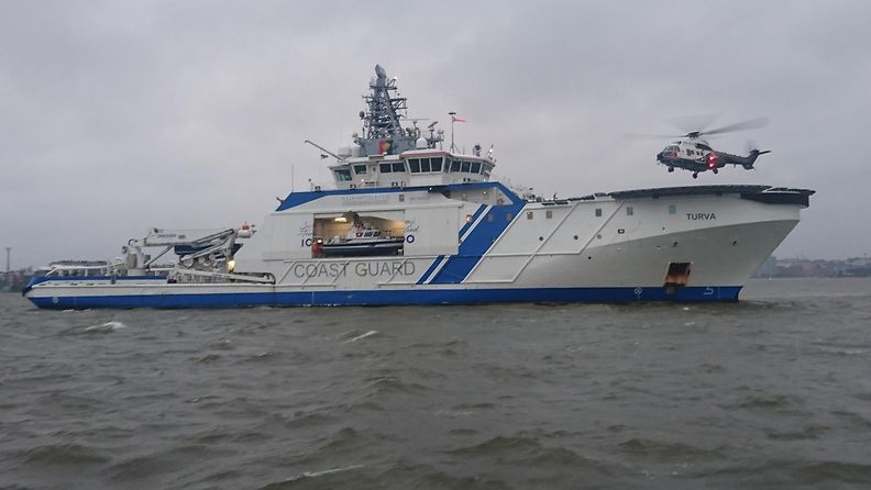 Vartiolaiva Turva antaa operaatiolle suojaa tuulelta. Luotsivene