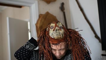 Ola Stinnerbom laittaa Sami-naamion päähänsä. Perinteisesti naamioita käyttävät shamaanit. 